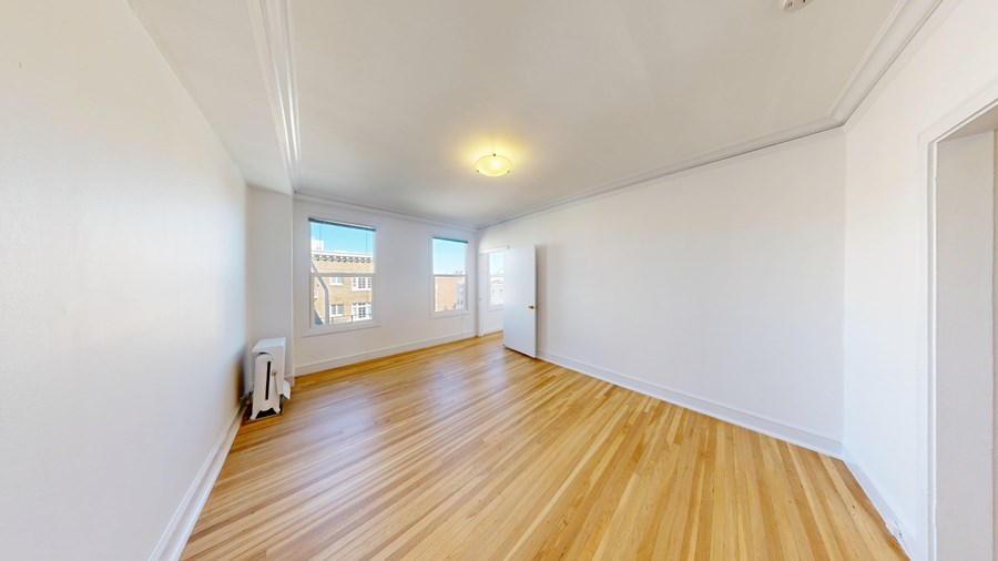 A room with wooden flooring and white walls.